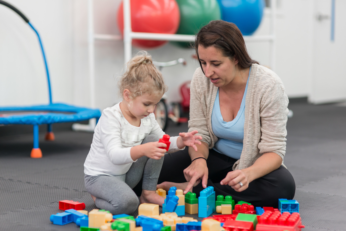 Occupational Therapist works with a young girl doing play therapy